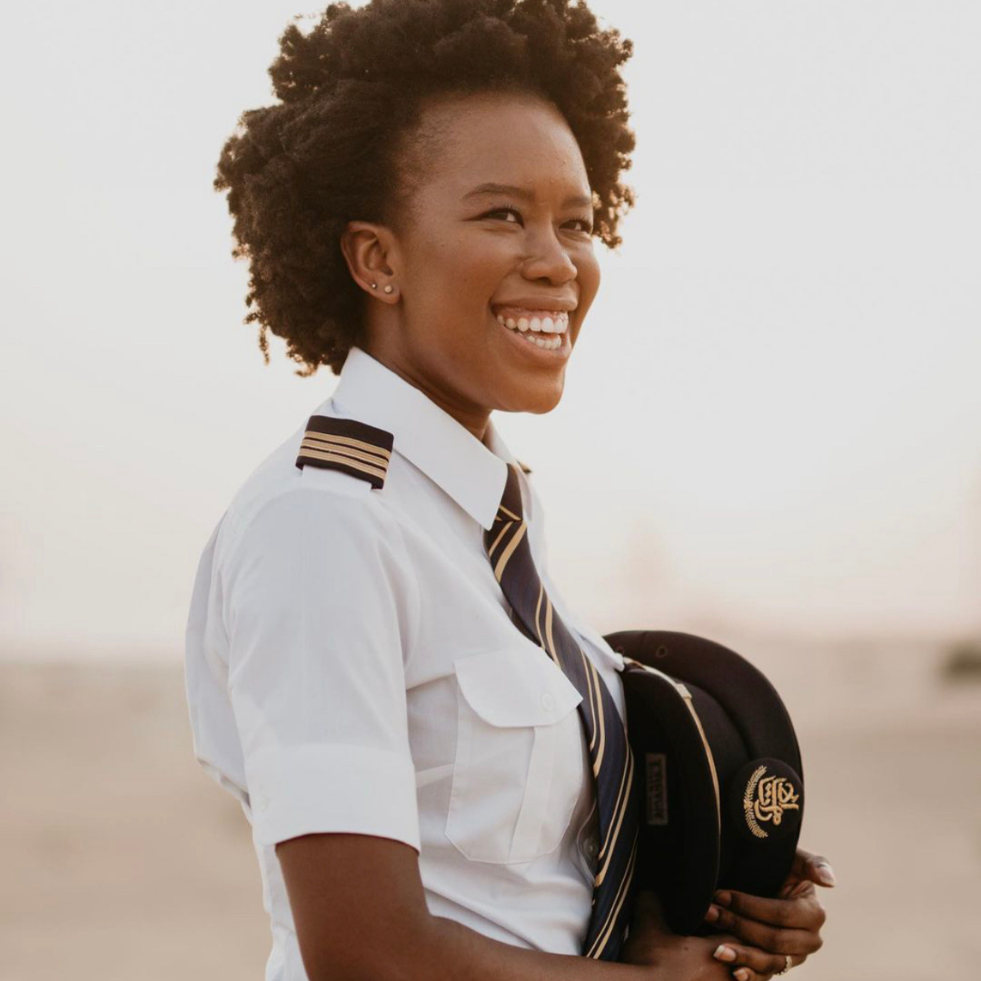 Black female pilot smiling in pilot's uniform - Amanda Kandawire-Khoza